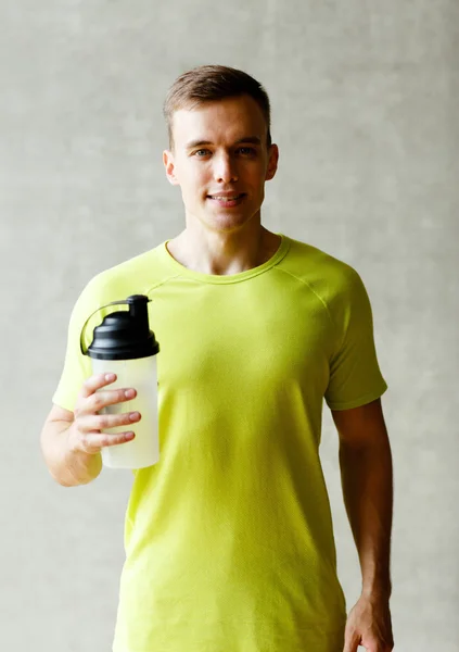 Homem sorridente com garrafa de batido de proteína — Fotografia de Stock
