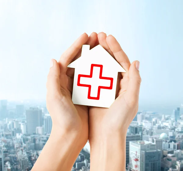 Hands holding paper house with red cross — Stock Photo, Image