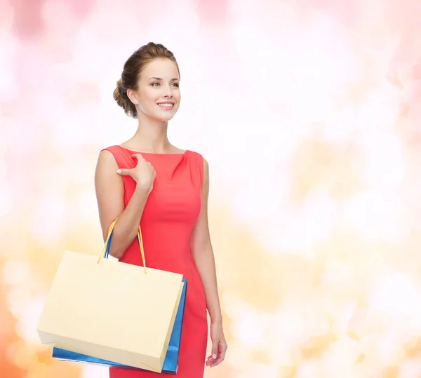 Mujer elegante sonriente en vestido con bolsas de compras —  Fotos de Stock