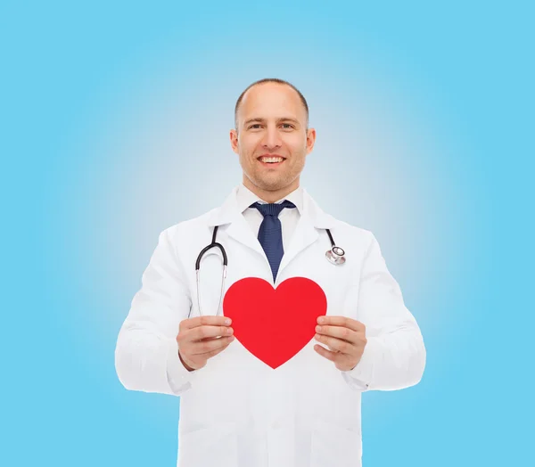 Smiling male doctor with red heart and stethoscope — Stock Photo, Image