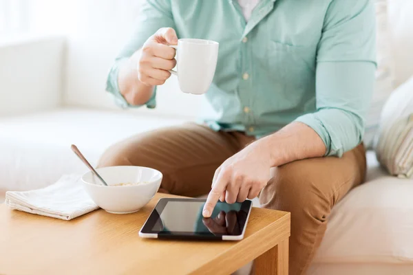 Close-up do homem com tablet pc tomando café da manhã — Fotografia de Stock