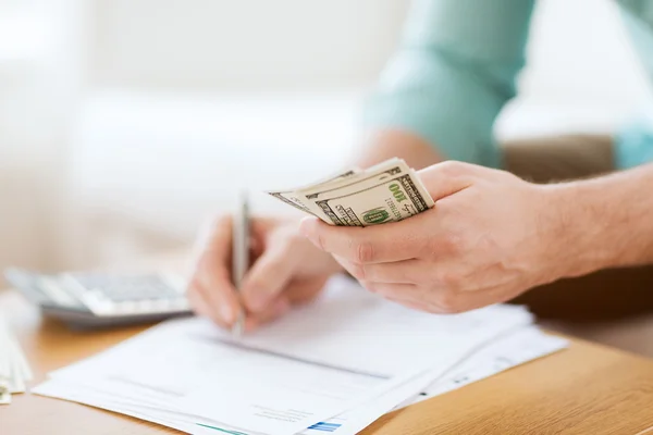 Close up of man counting money and making notes — Stock Photo, Image