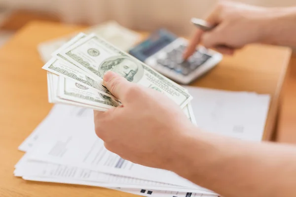 Close up of man counting money and making notes — Stock Photo, Image