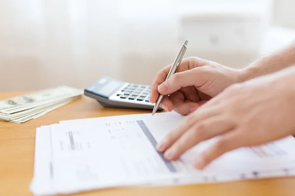 Close up of man counting money and making notes — Stock Photo, Image