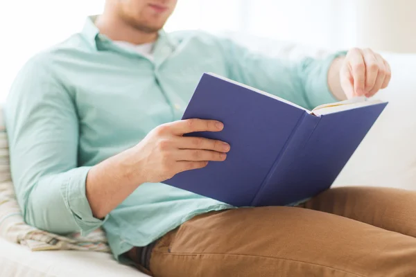 Närbild av man läser bok hemma — Stockfoto