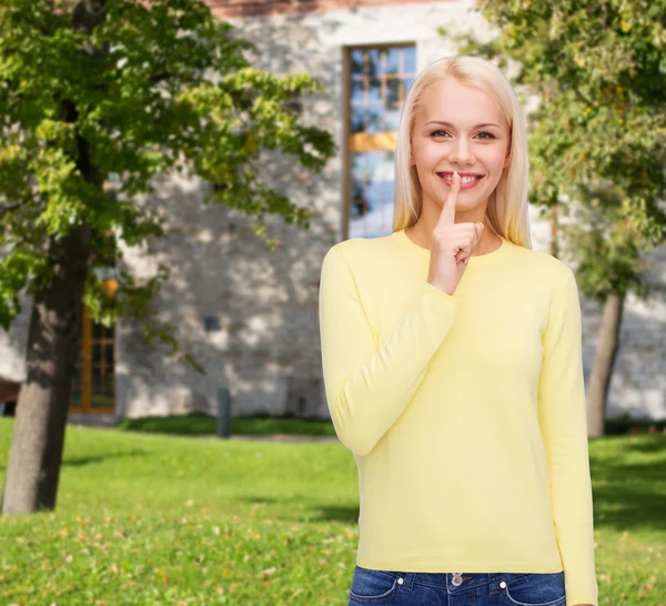 Ung kvinna med fingret på hennes läpp — Stockfoto