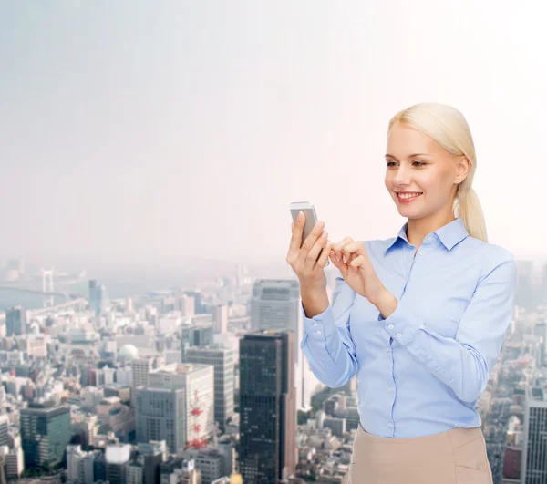 Jeune femme d'affaires souriante avec smartphone — Photo