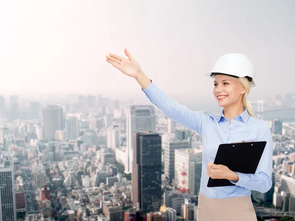 Smiling businesswoman in helmet with clipboard — Stock Photo, Image