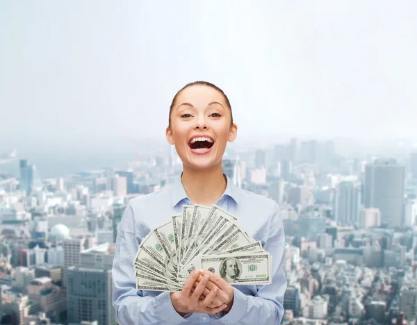 Mujer de negocios riendo con dinero en efectivo en dólares — Foto de Stock