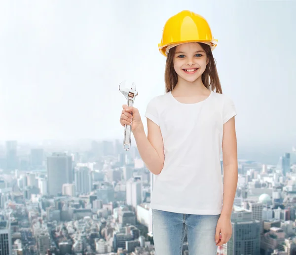 Smiling little girl in hardhat with wrench — Stock Photo, Image