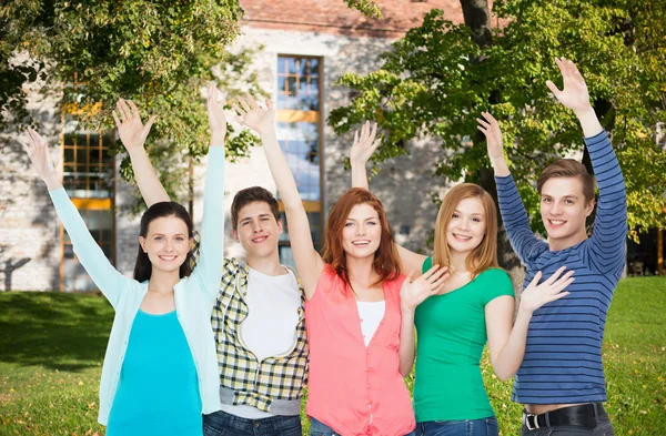 Grupp leende studenter viftande händer — Stockfoto