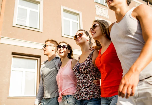 Group of smiling friends walking in city — Stock Photo, Image