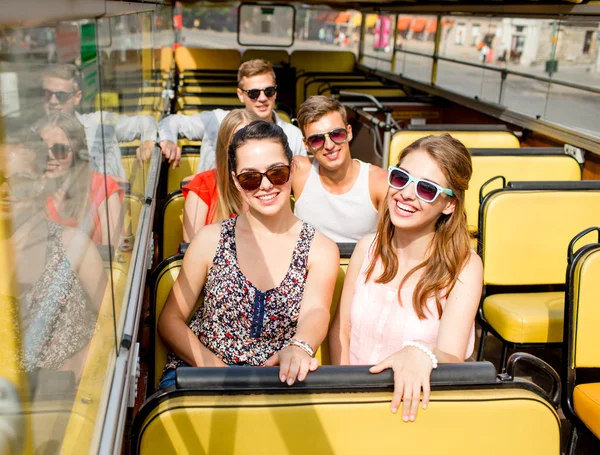Group of smiling friends traveling by tour bus — Stock Photo, Image