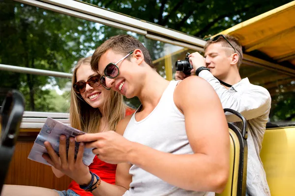 Sorrindo casal com livro viajando de ônibus de turismo — Fotografia de Stock