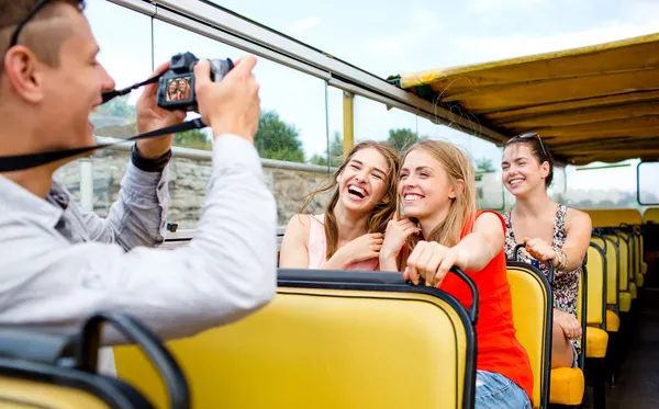 Amigos rindo com câmera viajando de ônibus de turismo — Fotografia de Stock