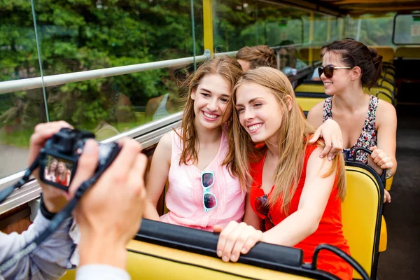 Amici sorridenti con macchina fotografica che viaggiano in autobus turistico — Foto Stock