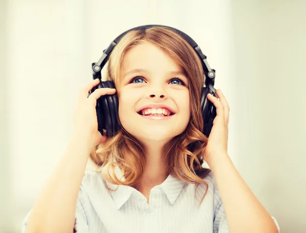 Bambina con le cuffie a casa — Foto Stock