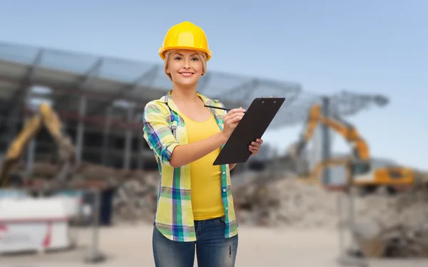 Mujer sonriente en casco con portapapeles — Foto de Stock