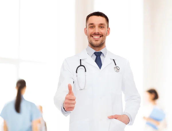 Médico sorridente com estetoscópio mostrando polegares para cima — Fotografia de Stock