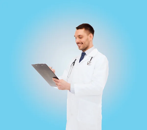 Smiling male doctor with clipboard and stethoscope — Stock Photo, Image