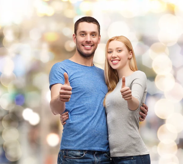 Smiling couple showing thumbs up — Stock Photo, Image