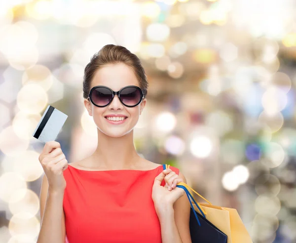 Smiling woman with shopping bags and plastic card — Stock Photo, Image