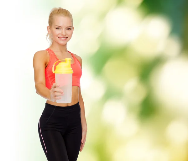 Lächelnde sportliche Frau mit Protein-Shake-Flasche — Stockfoto