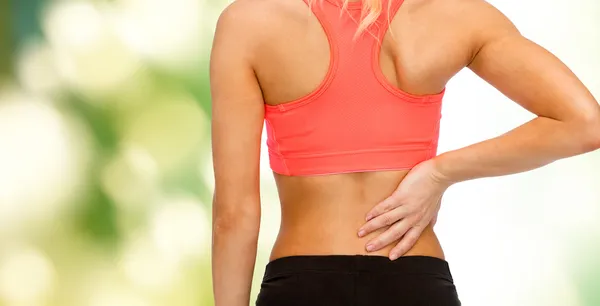 Close up of sporty woman touching her back — Stock Photo, Image