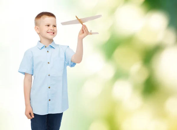 Usměvavý chlapeček drží dřevěné letadlo model — Stock fotografie