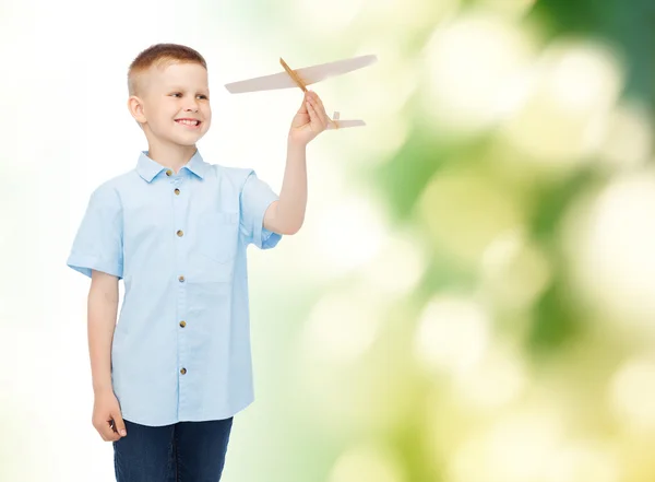 Lachende jongetje houden een houten vliegtuig model — Stockfoto