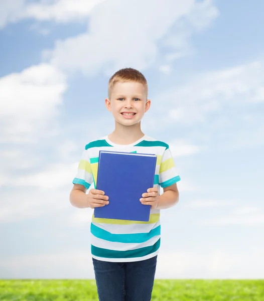 Petit garçon étudiant souriant avec livre bleu — Photo