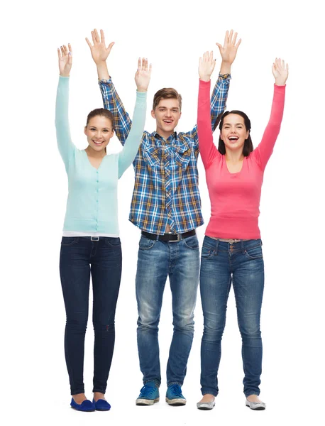 Group of smiling teenagers with raised hands — Stock Photo, Image