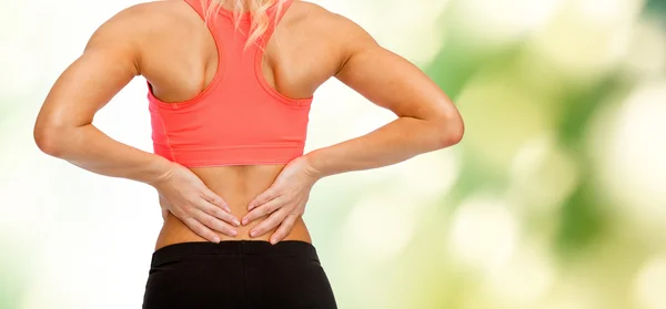 Close up of sporty woman touching her back Royalty Free Stock Photos