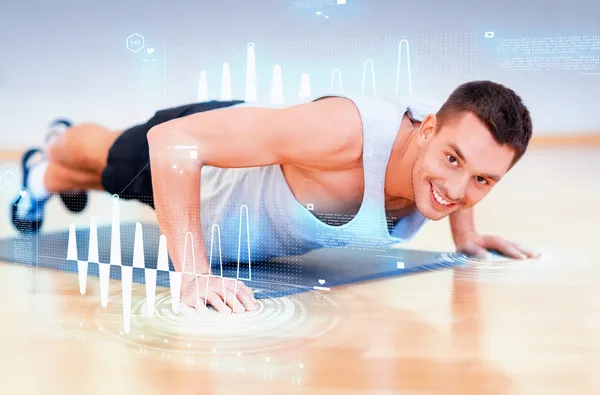 Hombre sonriente haciendo flexiones en el gimnasio — Foto de Stock