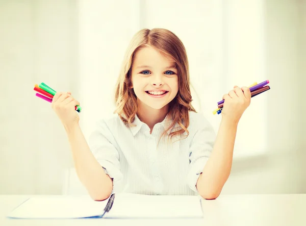 Leende flicka visar färgglada fiberpennor — Stockfoto