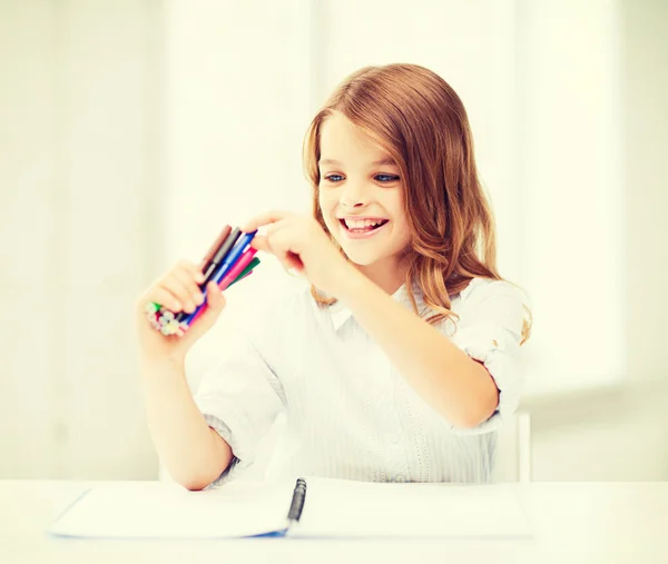 Menina sorridente escolhendo caneta colorida de feltro — Fotografia de Stock