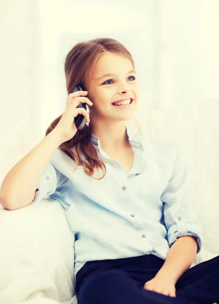 Χαμογελαστό κορίτσι με smartphone στο σπίτι — Φωτογραφία Αρχείου