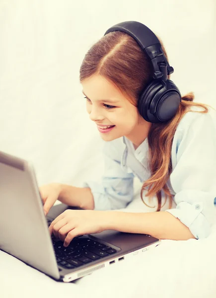 Dziewczyna z komputera przenośnego i słuchawki w domu — Zdjęcie stockowe