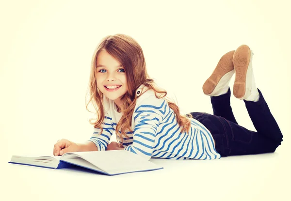 Sorridente piccola studentessa sdraiata sul pavimento — Foto Stock