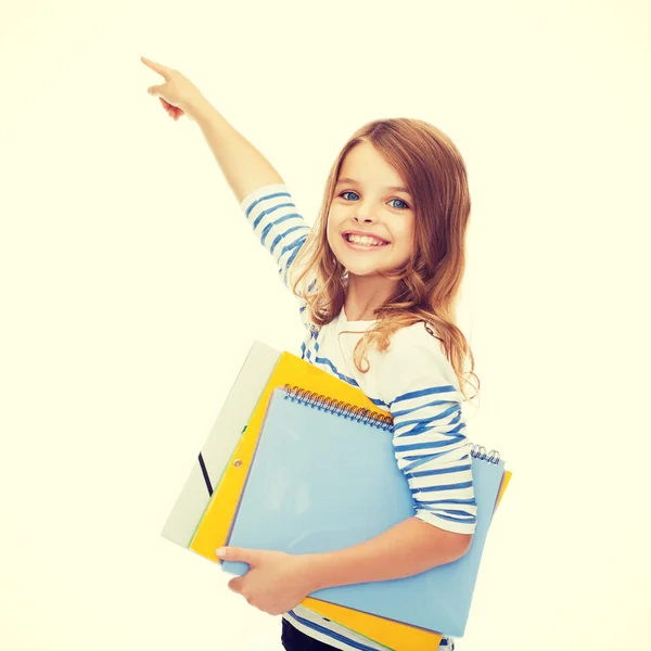 Menina bonito com pastas apontando para a tela virtual — Fotografia de Stock