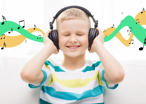 Smiling little boy with headphones at home — Stock Photo, Image