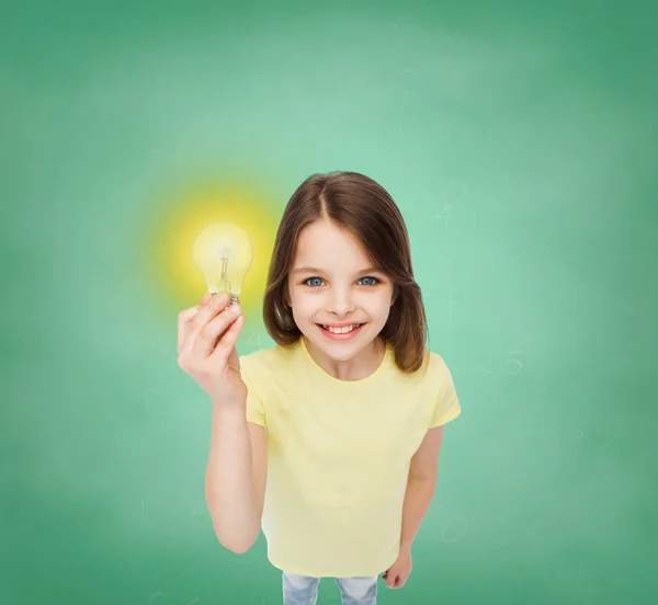微笑的小女孩抱着灯泡 — 图库照片
