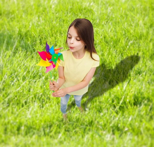 Criança sorridente com brinquedo colorido de moinho de vento — Fotografia de Stock