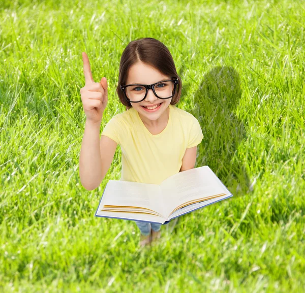 Smiling little girl in eyeglasses with book — Stock Photo, Image