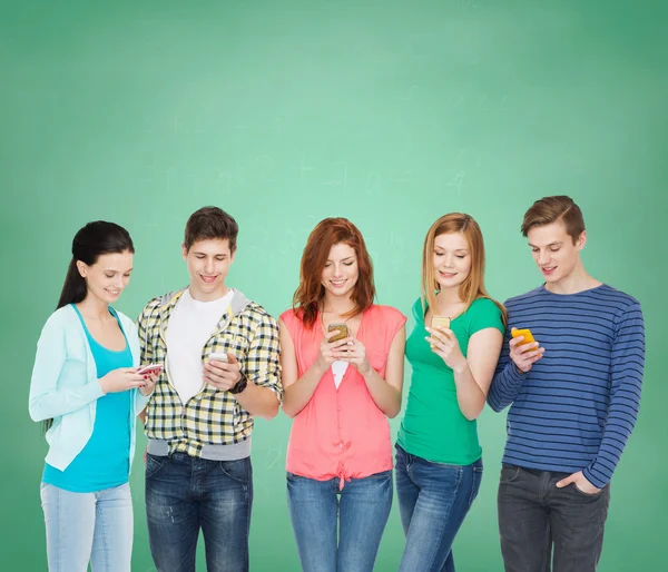 Usmívající se studenti s chytrými telefony — Stock fotografie