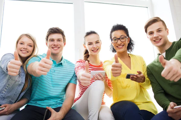 Smiling students with smartphone texting at school — Stock Photo, Image