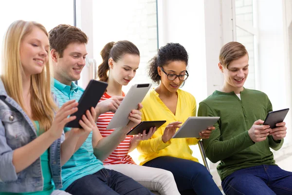 Lachende studenten met de tablet pc op school — Stockfoto