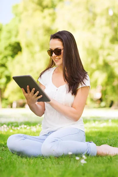 Sourire jeune fille avec tablette PC assis sur l'herbe — Photo