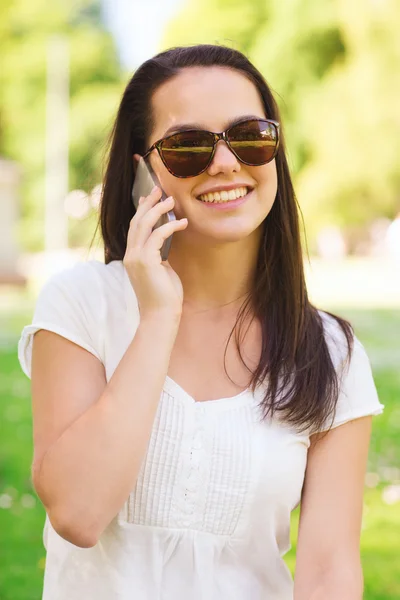 Glimlachend jong meisje met smartphone outdoors — Stockfoto