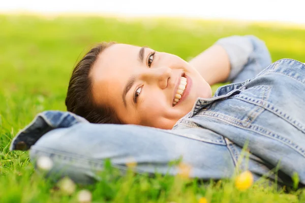 Sorrindo menina deitada na grama — Fotografia de Stock